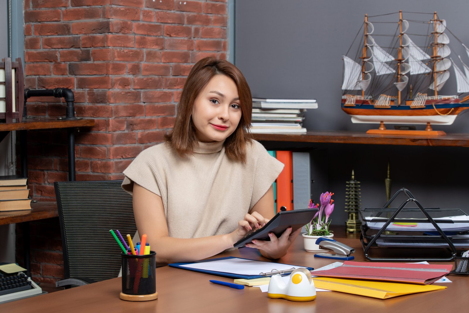 front-view-smiling-woman-using-calculator-sitting-wall